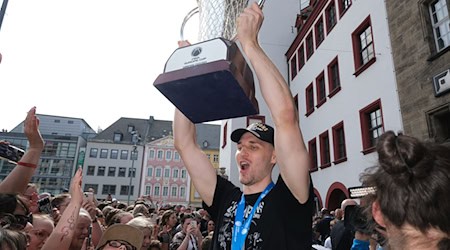 Jonas Richter, Kapitän des Basketballteams Niners Chemnitz, jubelt mit dem Pokal. / Foto: Sebastian Willnow/dpa