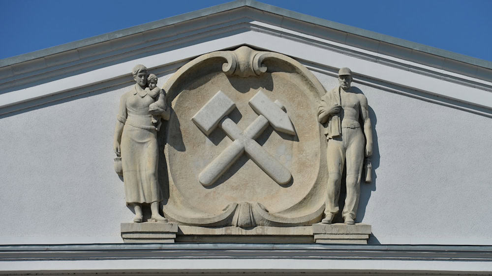 Ein Hammer und ein Meißel zieren die Fassade der einstigen Generaldirektion der SDAG Wismut in Chemnitz (Sachsen). / Foto: Hendrik Schmidt/dpa/Archivbild