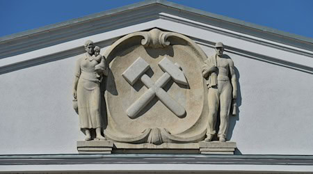 Ein Hammer und ein Meißel zieren die Fassade der einstigen Generaldirektion der SDAG Wismut in Chemnitz (Sachsen). / Foto: Hendrik Schmidt/dpa/Archivbild