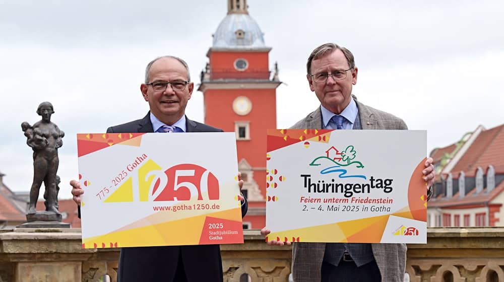 Gotha bereitet sich auf den Thüringentag 2025 vor. Ministerpräsident Bodo Ramelow (r.) und OB Knut Kreuch (SPD) mit den Logos von Landesfest und Stadtjubiläum vor dem Historischen Rathaus. / Foto: Martin Schutt/dpa