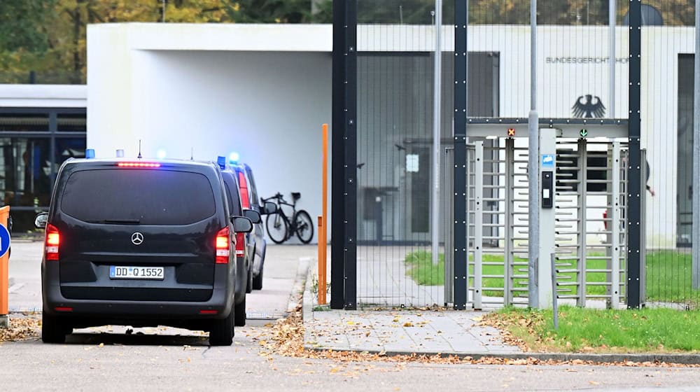 Mit eingeschaltetem Blaulicht fahren mehrere Wagen auf den Hof an der Außenstelle des Bundesgerichtshofs.  / Foto: Uli Deck/dpa