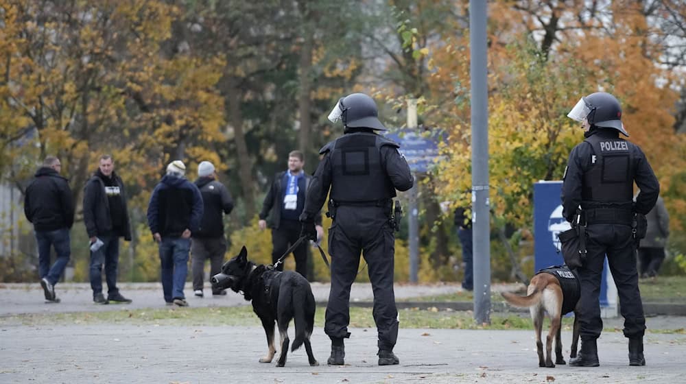 Fußballfans verließen das Olympiastadion nach dem Spiel der Hertha gegen Dynamo Dresden unter den kritischen Blicken etlicher Polizisten.  / Foto: Manuel Genolet/dpa