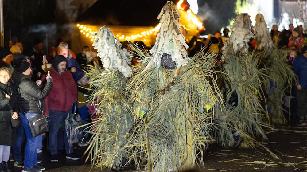 Mit lautem Schellen, Peitschenknallen und geheimnisvollen Schilfgestalten ist in Gethles Weihnachten eingeläutet worden. / Foto: Michael Reichel/dpa
