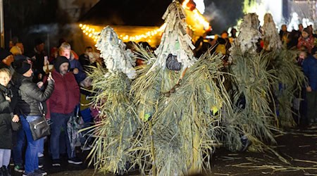 Mit lautem Schellen, Peitschenknallen und geheimnisvollen Schilfgestalten ist in Gethles Weihnachten eingeläutet worden. / Foto: Michael Reichel/dpa