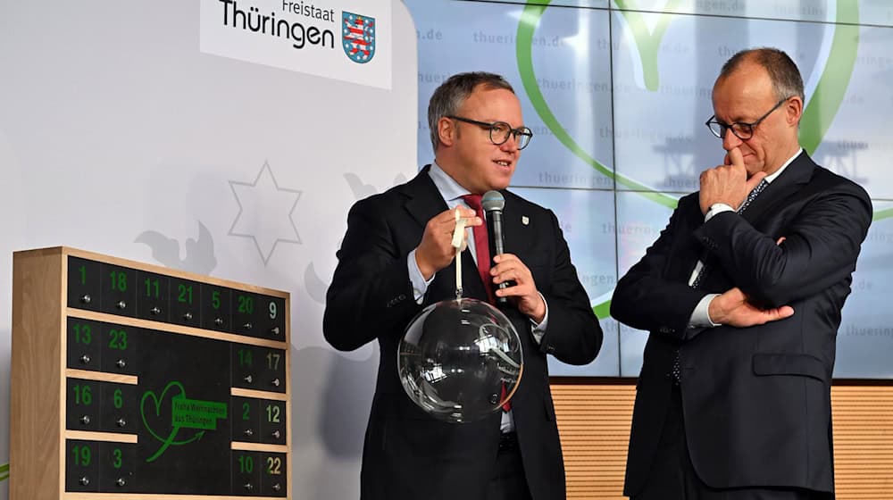 Thüringens Ministerpräsident Mario Voigt übergab Bundeskanzler Friedrich Merz (beide CDU) eine gläserne Weihnachtskugel. Das Weihnachtsfest verbringt der 48-Jährige im Kreise seiner Familie. (Archivbild) / Foto: Martin Schutt/dpa