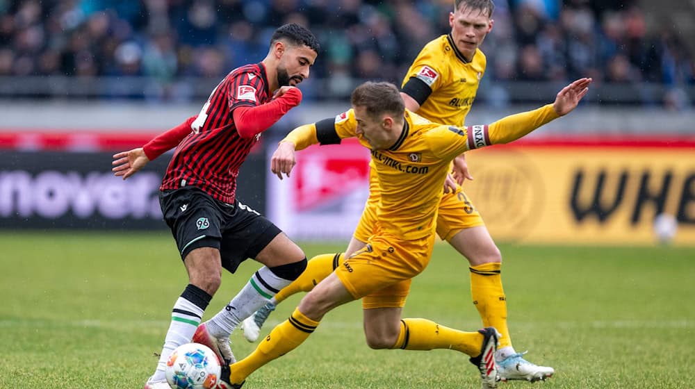 Elias Saad (Hannover 96) (l-r), Niklas Hauptmann (Dynamo Dresden) und Jonas Sterner (Dynamo Dresden) kämpfen um den Ball. / Foto: David Inderlied/dpa