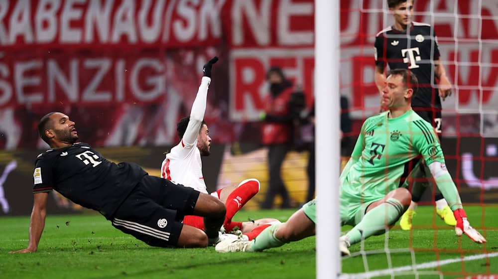 Rômulo (M, RB Leipzig) erzielt den Treffer zum 1:0 gegen Jonathan Tah (l, Bayern München) und Torwart Manuel Neuer (Bayern München). Um ins Pokal-Halbfinale zu kommen, müssen die Leipziger wieder treffen. (Archivbild) / Foto: Jan Woitas/dpa