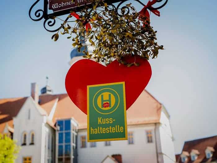 Rotes Herz und Mistelzweig: Auf dem Marktplatz in Eisenberg ist Küssen ausdrücklich erwünscht. / Foto: Jacob Schröter/dpa