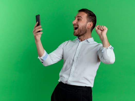 Mann jubelt über No-Deposit Bonus auf dem Smartphone