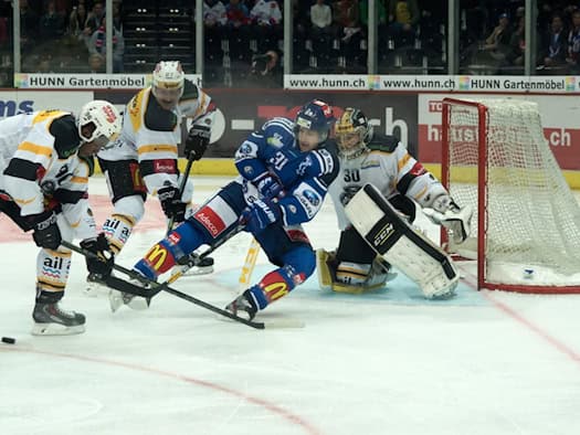 Spannende Szene vor dem Tor: Eishockeyspieler kämpfen um den Puck in der DEL