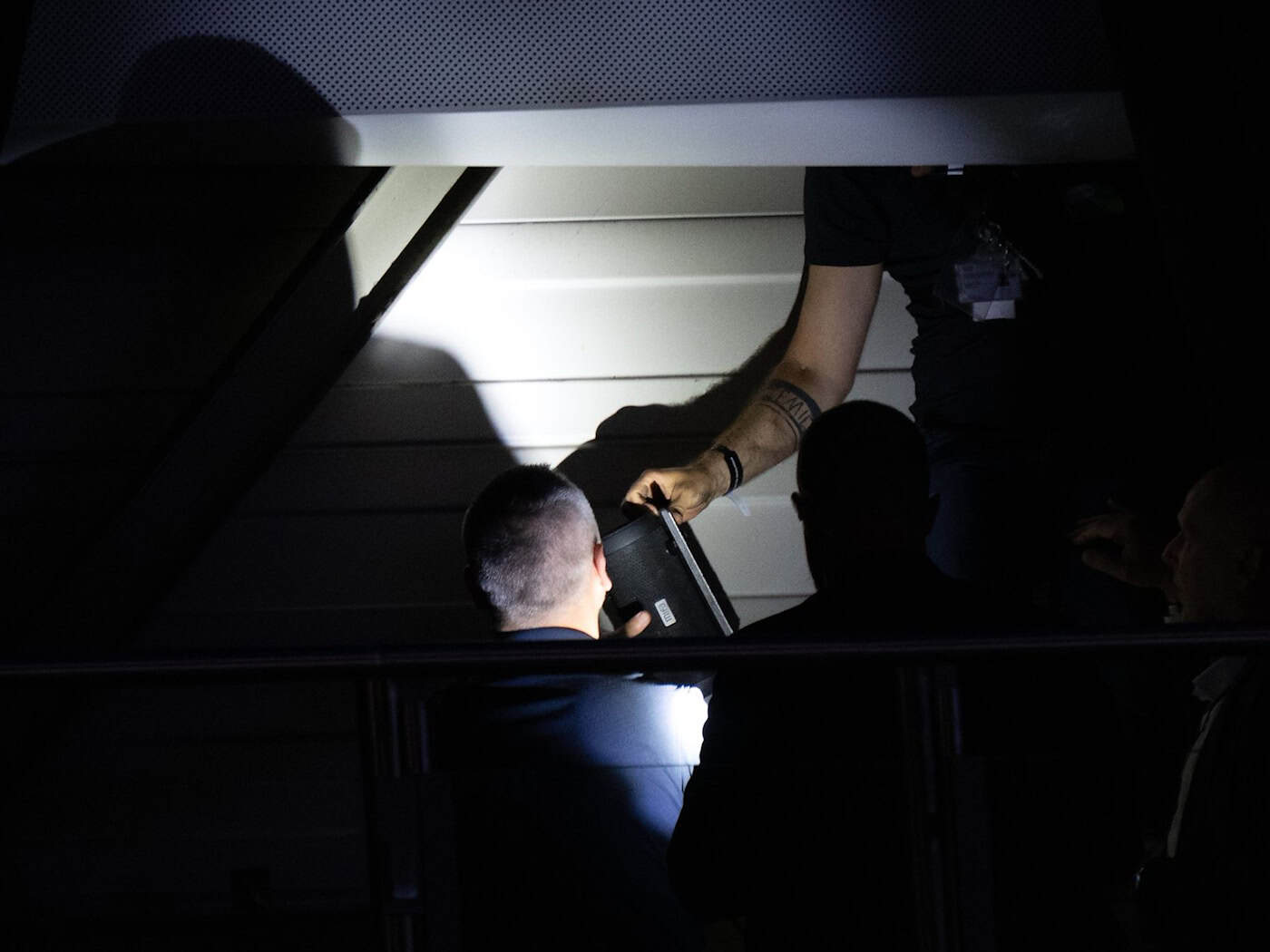 Hinter einem Vorhang am Hallendach spüren Techniker eine Blutooth-Box auf.  / Foto: Sebastian Kahnert/dpa