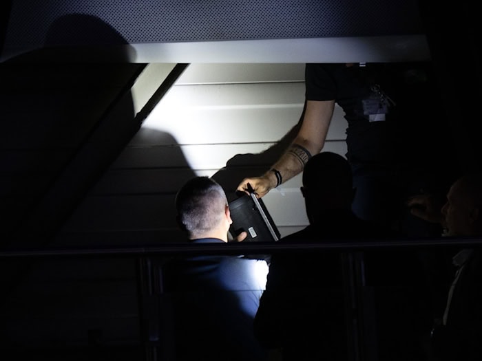 Hinter einem Vorhang am Hallendach spüren Techniker eine Blutooth-Box auf.  / Foto: Sebastian Kahnert/dpa