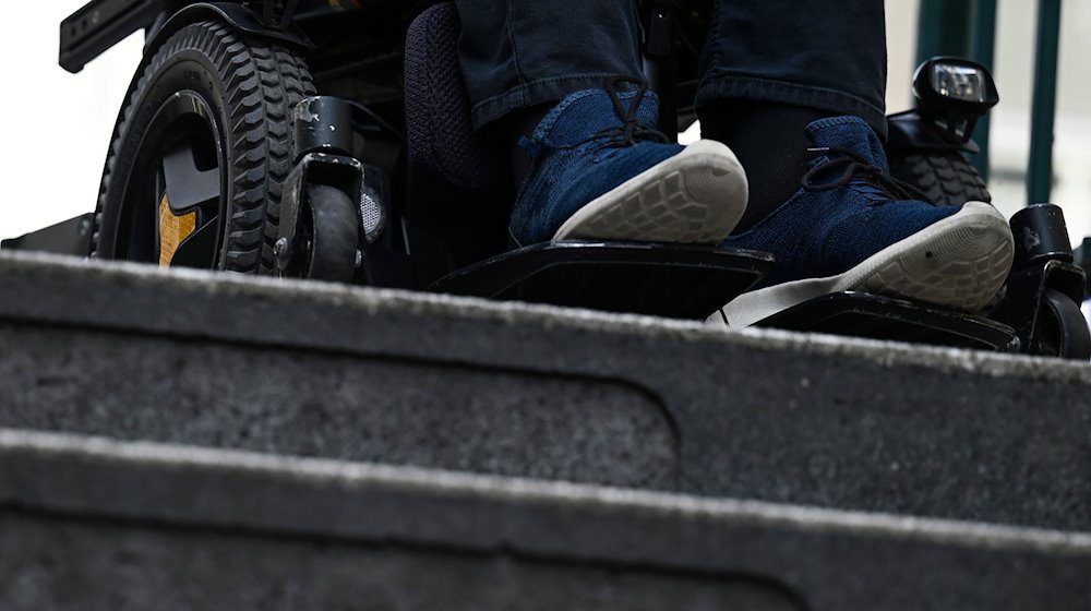 Ein Mann steht mit seinem Rollstuhl vor der Treppe eines Eingangs zur U-Bahn. / Foto: Jessica Lichetzki/dpa