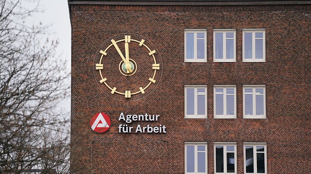 Die Uhr an der Fassade der Agentur für Arbeit zeigt fünf Minuten vor Zwölf an. / Foto: Marcus Brandt/dpa