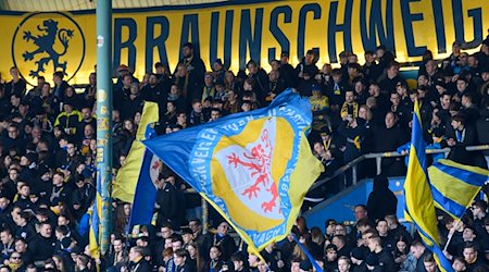 Fans von Eintracht Braunschweig schwenken ihre Flaggen. / Foto: Swen Pförtner/dpa