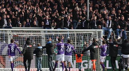 Osnabrücks Spieler feiern den Sieg bei Spielende mit den Fans. / Foto: Friso Gentsch/dpa