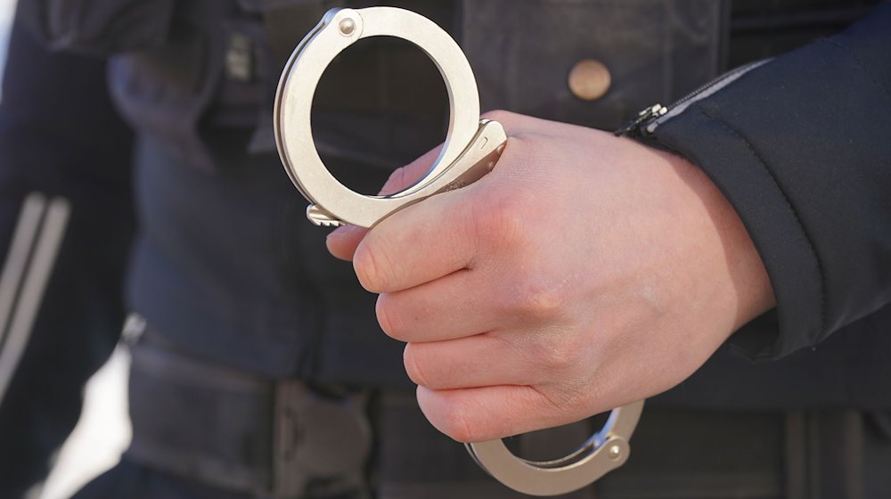 Ein Polizist hält Handschellen in der Hand. / Foto: Marcus Brandt/dpa