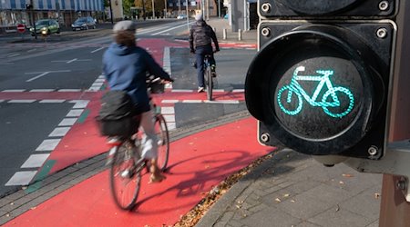 Zwei Radfahrer fahren auf dem Radweg an einer grünen Ampel vorbei. / Foto: Demy Becker/dpa