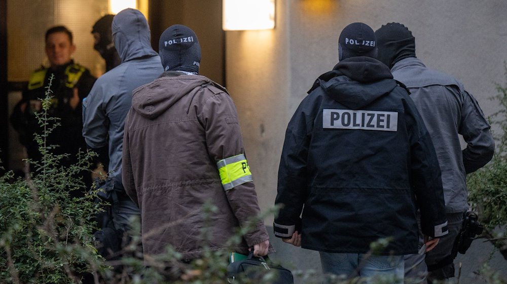 Maskierte Polizisten betreten das Wohnhaus der früheren RAF-Terroristin Daniela Klette in Berlin-Kreuzberg. / Foto: Monika Skolimowska/dpa
