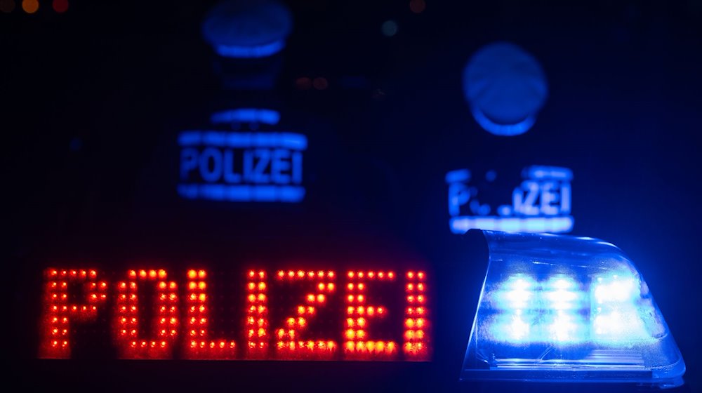 Zwei Polizisten stehen vor einem Streifenwagen. / Foto: Marijan Murat/dpa/Symbolbild