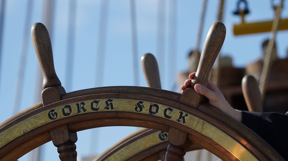 «Gorch Fock» steht auf dem Steuerrad auf der Brücke des Segelschulschiffs «Gorch Fock». / Foto: Marcus Brandt/dpa
