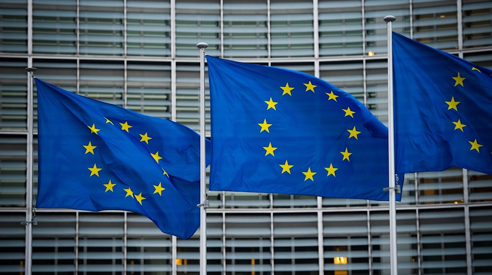 Flaggen der Europäischen Union wehen im Wind vor dem Berlaymont-Gebäude der Europäischen Kommission in Brüssel. / Foto: Arne Immanuel Bänsch/dpa