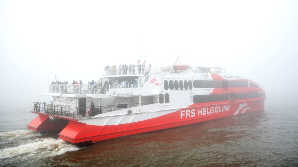 Der Helgoland-Katamaran «Halunder Jet» legt am Morgen im dichten Nebel im Hafen auf der Elbe in Richtung der Nordseeinsel Helgoland ab. / Foto: Daniel Bockwoldt/dpa