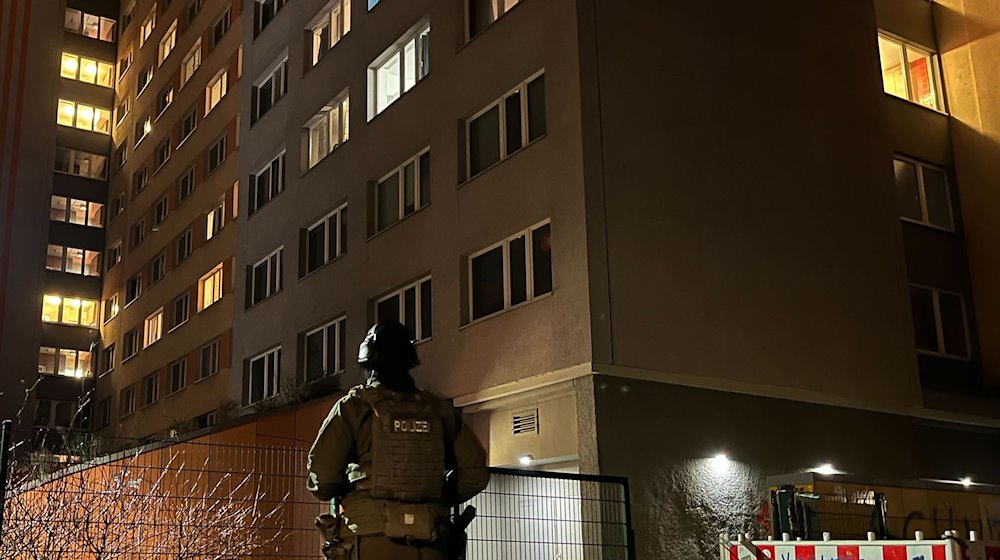 Ein Polizist steht vor einem Hochhaus in Berlin-Friedrichshain. / Foto: Dominik Totaro/dpa