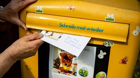 Ein Brief, den ein Kind für den Osterhasen geschrieben hat, wird in einen Briefkasten geworfen. / Foto: Sina Schuldt/dpa/Symbolbild