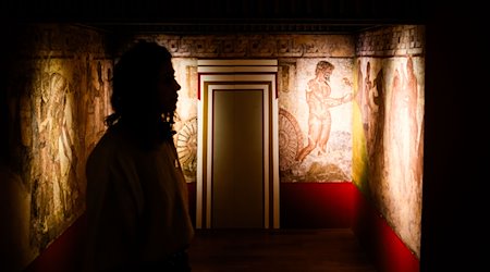 Eine Frau steht in der Ausstellung «Gründer Roms. Etruskische Schätze aus der Villa Giulia». / Foto: Julian Stratenschulte/dpa