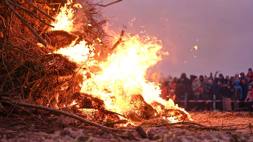 Ein Osterfeuer am Strand lockt zahlreiche Zuschauer an. / Foto: Lars Penning/dpa