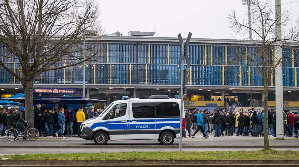 Ein Polizeiwagen steht vor dem Spiel vor dem Stadion. / Foto: David Inderlied/dpa