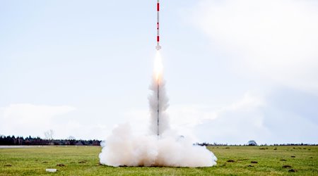Eine mit mehreren Minisatelliten bestückte Rakete startet 2023 von einer Wiese auf dem Flugplatz. / Foto: Hauke-Christian Dittrich/dpa