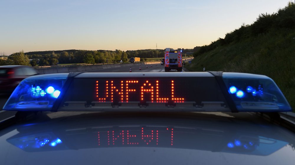 Ein Polizeifahrzeug warnt mit einer Leuchtschrift vor einer Unfallstelle. / Foto: Stefan Puchner/dpa