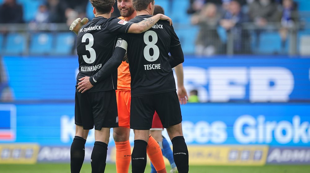 Osnabrücks Florian Kleinhansl (l-r), Torwart Philipp Kühn und Robert Tesche freuen sich nach dem Spiel. / Foto: Christian Charisius/dpa