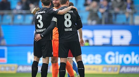 Osnabrücks Florian Kleinhansl (l-r), Torwart Philipp Kühn und Robert Tesche freuen sich nach dem Spiel. / Foto: Christian Charisius/dpa