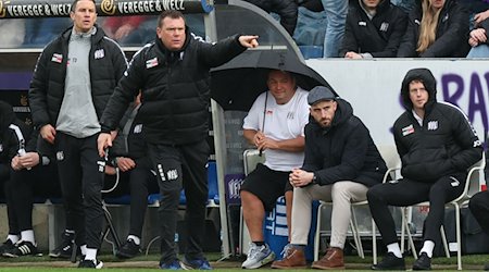 Osnabrücks Co-Trainer Tim Danneberg (l-r), Trainer Uwe Koschinat, Zeugwart Mario Richter und Leiter Lizenzbereich, Julius Ohnesorge und Teammanager Leon Seelhöfer steht an der Seitenlinie. / Foto: Friso Gentsch/dpa