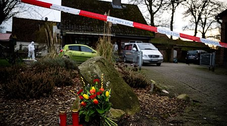 Blumen und Kerzen liegen vor einem Einfamilienhaus in der Gemeinde Scheeßel. / Foto: Sina Schuldt/dpa