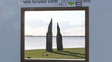 «Viele Grüße vom Dümmer-See» steht auf einem Holzrahmen mit Blick auf den See. / Foto: Friso Gentsch/dpa