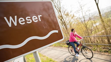 Eine Fahrradfahrerin fährt auf dem Weser-Radweg. / Foto: Moritz Frankenberg/dpa/Archivbild