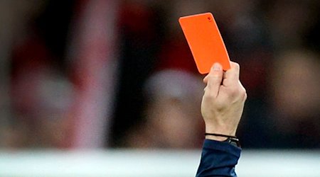 Ein Schiedsrichter zeigt einem Fußballspieler die Rote Karte. / Foto: Patrick Seeger/dpa