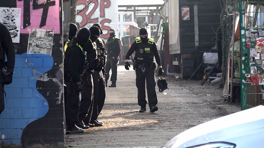 Einsatzkräfte stehen an einem Grundstück. / Foto: Paul Zinken/dpa