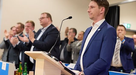 Frank Rinck, (AfD, r), Landesvorsitzender, steht beim Landesparteitag der AfD Niedersachsen auf der Bühne. / Foto: Georg Wendt/dpa