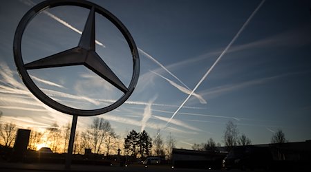 Die Sonne geht hinter einem Mercedes-Stern auf dem Mercedes-Benz-Werk auf. / Foto: Sebastian Gollnow/dpa