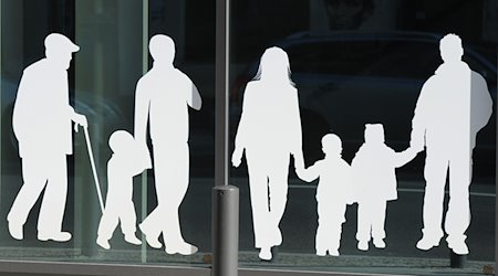 Silhouetten von Menschen in verschiedenem Alter sind auf Fensterscheiben aufgeklebt. / Foto: Jens Kalaene/dpa/Archivbild