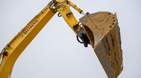 Die Schaufel eines Baggers ragt auf einer Baustelle in den Himmel. / Foto: Klaus-Dietmar Gabbert/dpa/Symbolbild