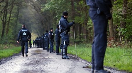 Eine Hundertschaft der Polizei durchsucht ein Waldgebiet bei Bremervörde. / Foto: Markus Hibbeler/dpa