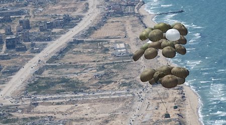 Fallschirme mit Lebensmitteln schweben nach dem Abwurf aus einer Transportmaschine der Luftwaffe über dem Gazastreifen. / Foto: Boris Roessler/dpa/Archivbild