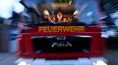 Einsatzkräfte der Feuerwehr sitzen in ihrem Fahrzeug. / Foto: Carsten Rehder/dpa