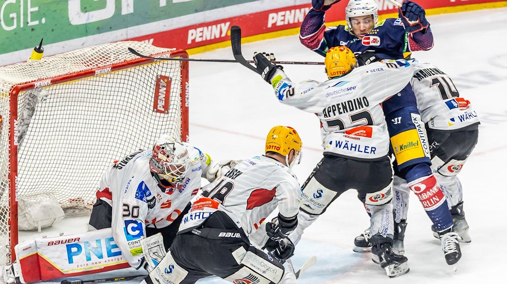 Ross Mauermann (r) und Nicolas Appendino (3.v.r) von Pinguins Bremerhaven verteidigen das Tor. / Foto: Andreas Gora/dpa